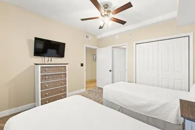 a bedroom with two beds and a flat screen tv at Emerald Coast Escapes in Panama City Beach