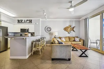 a kitchen and living room with a couch and a table at Shores of Panama 723 condo in Panama City Beach
