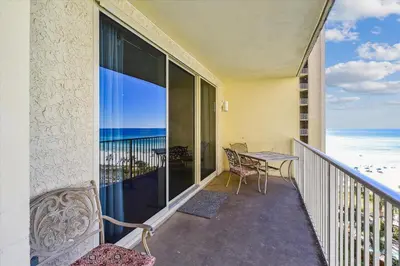 a balcony with a table and chairs and the ocean at Shores of Panama 723 condo in Panama City Beach
