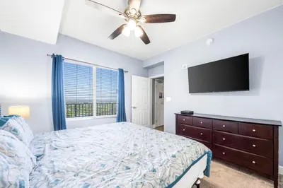 a bedroom with a bed and a flat screen tv at Beautiful Beach front condo! - Tidewater 1804 in Panama City Beach