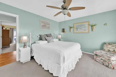 a bedroom with a white bed and a ceiling fan at All Decked Out on PCB in Panama City Beach
