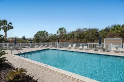 a large swimming pool with benches around it at All Decked Out on PCB in Panama City Beach
