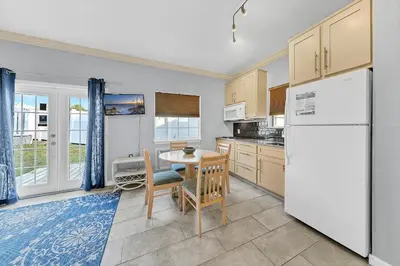 a kitchen with a white refrigerator and a table and chairs at The Palms A6 in Panama City Beach