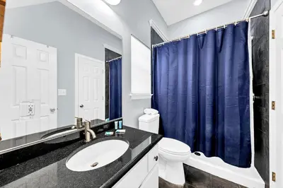 a bathroom with a sink and a blue shower curtain at The Palms A6 in Panama City Beach