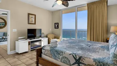 a bedroom with a bed and a view of the ocean at Tidewater 1312 in Panama City Beach