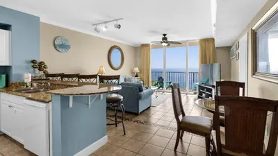 a kitchen and living room with a view of the ocean at Tidewater 1312 in Panama City Beach