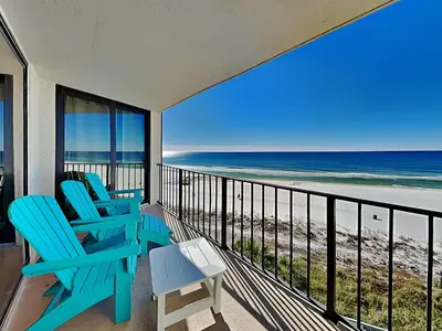 a balcony with two blue chairs and the beach at Edgewater Tower Iii 504 in Panama City Beach