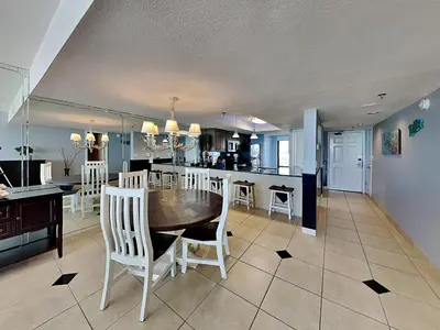 a kitchen and dining room with a table and chairs at Edgewater Tower Iii 504 in Panama City Beach