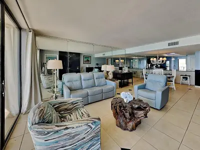 a living room with couches chairs and a table at Edgewater Tower Iii 504 in Panama City Beach
