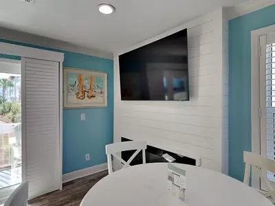 a dining room with a table and a tv on the wall at Beachside Villas 911 in Seagrove Beach