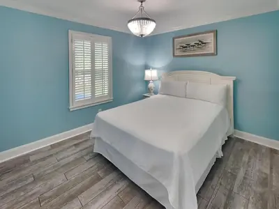 a bedroom with a white bed and blue walls at Beachside Villas 911 in Seagrove Beach