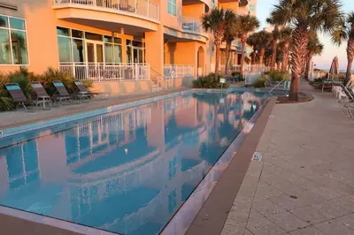 a swimming pool in front of a building at AQUA 1504 Beachfront condo with Free Beach Chairs in Panama City Beach