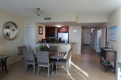 a dining room and kitchen with a table and chairs at AQUA 1504 Beachfront condo with Free Beach Chairs in Panama City Beach