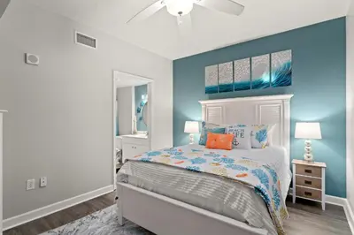a bedroom with a bed and a blue wall at Shores Of Panama #0323 in Panama City Beach