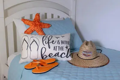 a bed with a hat and flip flops and a beach sign at Shores Of Panama #0912 in Panama City Beach