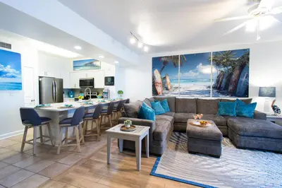 a living room with a couch and a table and a kitchen at Shores Of Panama #0912 in Panama City Beach