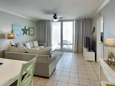 a living room with a couch and a tv at Emerald Beach #936 in Panama City Beach