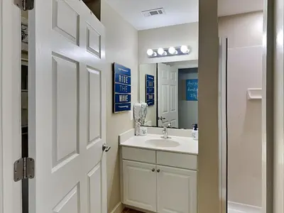a white bathroom with a sink and a mirror at Tidewater Beach Resort #1306 - Beach Bliss in Panama City Beach