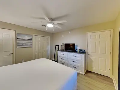 a bedroom with a white bed and a tv at Tidewater Beach Resort #1306 - Beach Bliss in Panama City Beach