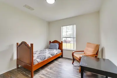 a bedroom with a bed and a chair and a piano at PCB Condo with Pool Access 1 Mi to Beach! in Panama City Beach