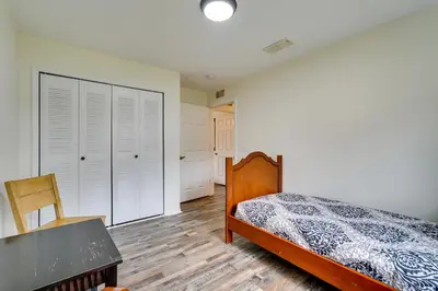 a bedroom with a bed and a table and chair at PCB Condo with Pool Access 1 Mi to Beach! in Panama City Beach