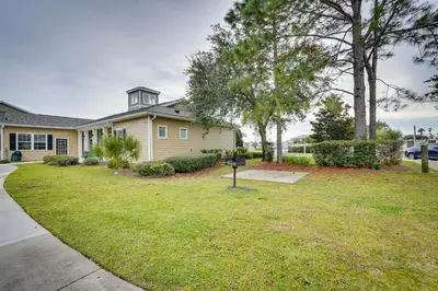 a house with a yard with a sign in the grass at PCB Condo with Pool Access 1 Mi to Beach! in Panama City Beach
