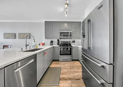a kitchen with gray cabinets and stainless steel appliances at Twin Palms 1802 in Panama City Beach