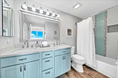 a bathroom with a sink and a toilet and a mirror at Twin Palms 1802 in Panama City Beach