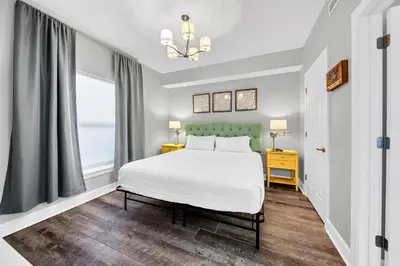 a bedroom with a white bed and a chandelier at Twin Palms 1802 in Panama City Beach
