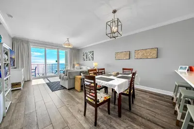 a living room with a table and chairs and a couch at Twin Palms 1802 in Panama City Beach