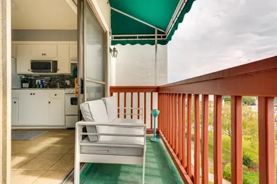 a porch with a white chair on a balcony at Panama City Beach Getaway - Walk to Beaches! in Panama City Beach