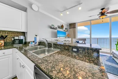 a kitchen with a sink and a large window at Tidewater 1113 in Panama City Beach
