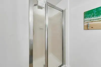 a shower with a glass door in a bathroom at Tidewater 1113 in Panama City Beach