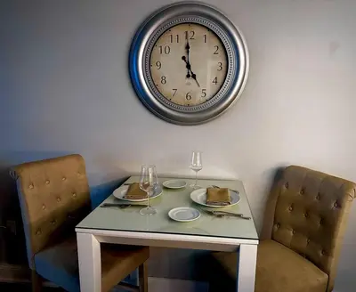 a table with two chairs and a clock on the wall at Melan Villa Costal Magic Ocean View in Panama City Beach