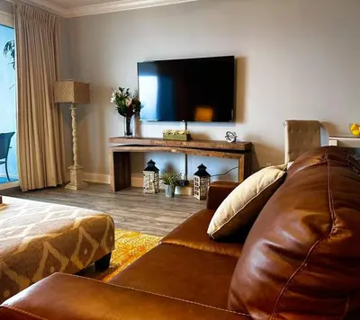 a living room with a couch and a flat screen tv at Melan Villa Costal Magic Ocean View in Panama City Beach