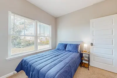 a bedroom with a blue bed and a window at Walk to Eats! Family Hideaway 16 Mi to PCB in Callaway