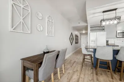 a kitchen and dining room with a wooden table and chairs at Laketown Wharf #1007 by Nautical Properties in Panama City Beach