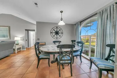 a dining room with a table and chairs and a window at Manatee Summer House in Panama City Beach