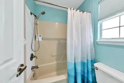 a bathroom with a shower with a shower curtain at Manatee Summer House in Panama City Beach