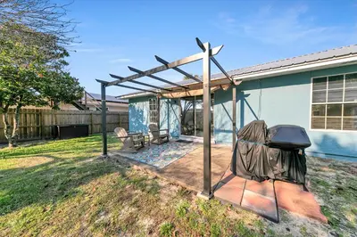 a pergola in the backyard of a house at Manatee Summer House in Panama City Beach