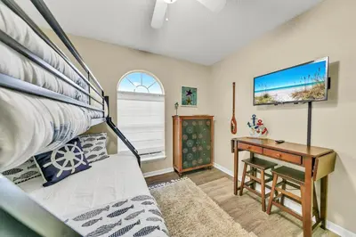 a bedroom with a bunk bed and a desk at Manatee Summer House in Panama City Beach