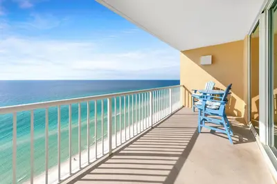 a balcony with a blue chair and the ocean at Majestic Beach Towers 1-2015 in Panama City Beach