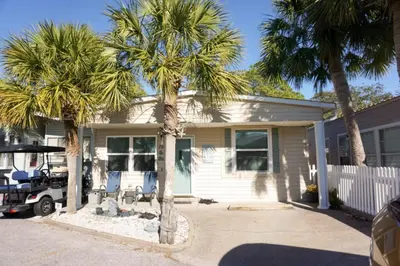 a house with two palm trees in front of it at Venture Out 79 Gulf Loop Comes With Golf Cart in Panama City Beach