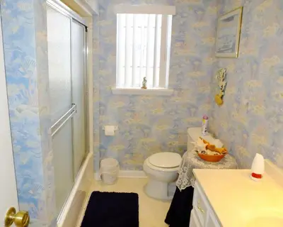 a bathroom with a toilet and a shower and a window at Venture Out 79 Gulf Loop Comes With Golf Cart in Panama City Beach
