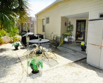 a patio with a table and chairs in front of a house at Venture Out 79 Gulf Loop Comes With Golf Cart in Panama City Beach