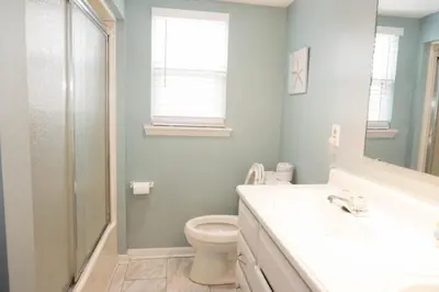 a bathroom with a toilet and a sink and a mirror at Venture Out 79 Gulf Loop Comes With Golf Cart in Panama City Beach