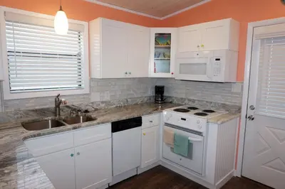 a kitchen with white cabinets and a sink at Venture Out 41 Gulf Loop 2bd 1ba WITH GOLF CART in Panama City Beach