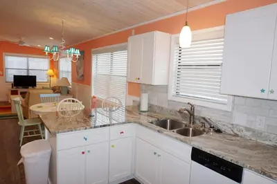 a kitchen with white cabinets and a sink at Venture Out 41 Gulf Loop 2bd 1ba WITH GOLF CART in Panama City Beach