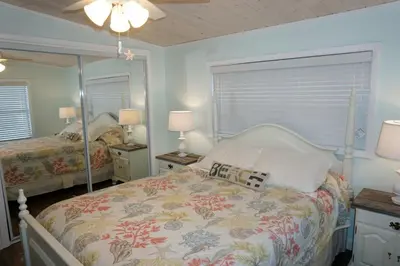 a bedroom with two beds and a large mirror at Venture Out 41 Gulf Loop 2bd 1ba WITH GOLF CART in Panama City Beach