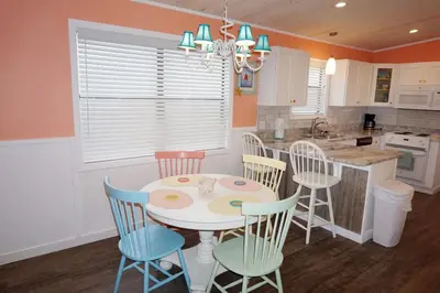 a kitchen with a white table and chairs at Venture Out 41 Gulf Loop 2bd 1ba WITH GOLF CART in Panama City Beach